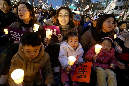 세자매가 아이들과 함께 촛불시위에 참여하고 있다. 